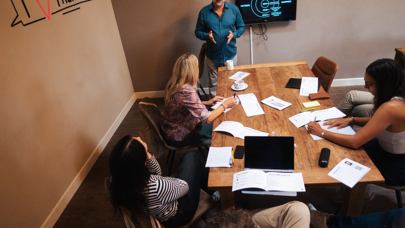 Small groups working around tables during a collaborative session